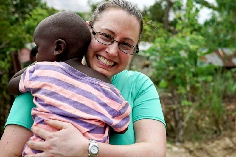 Closeup of Pam Martin holding a child.