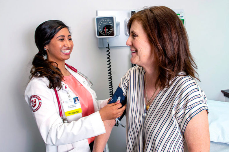 Medical student taking a patient's blood pressure.