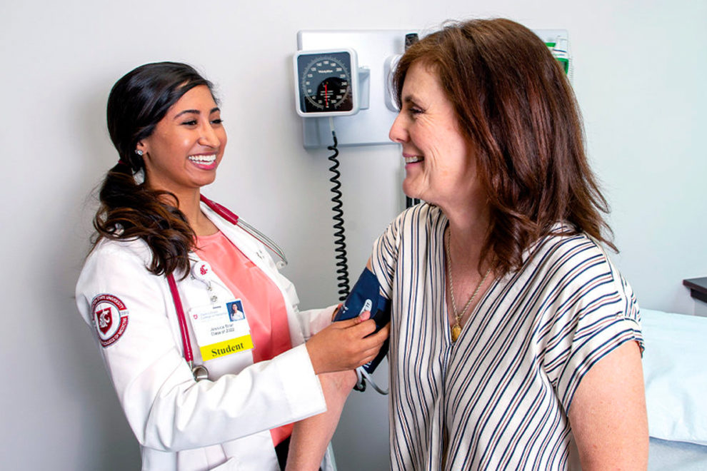 Medical student taking a patient's blood pressure.