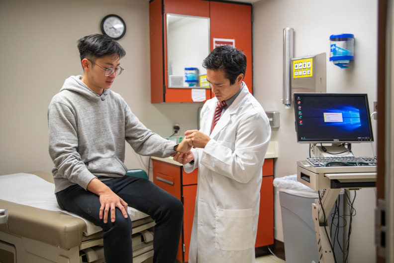 Physician Leyen Vu examines a student at Cougar Health Services.
