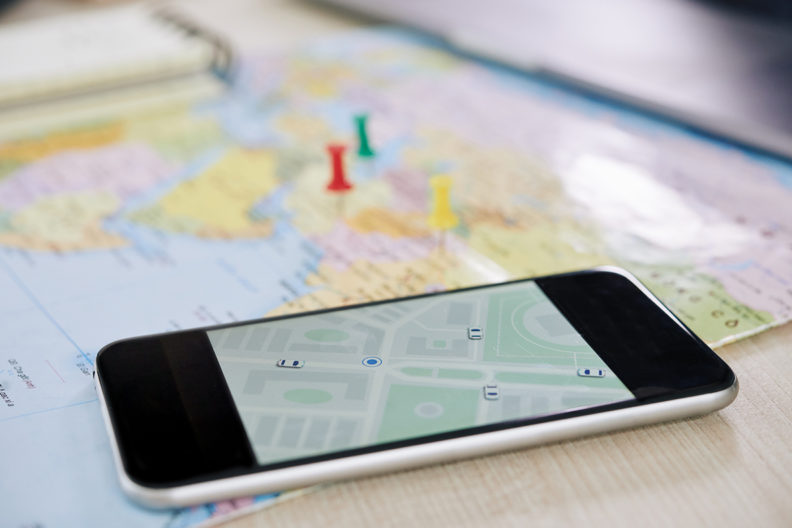 A map with a smart phone placed on top of it.