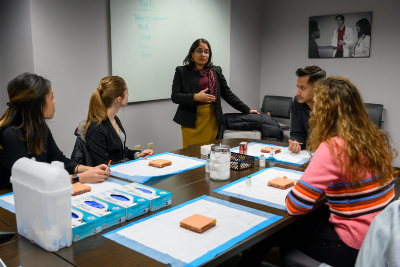 Radha Nandagopal convening with students around a table