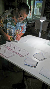 Frank Wallace uses templates to cut out the fabric for each mask. 