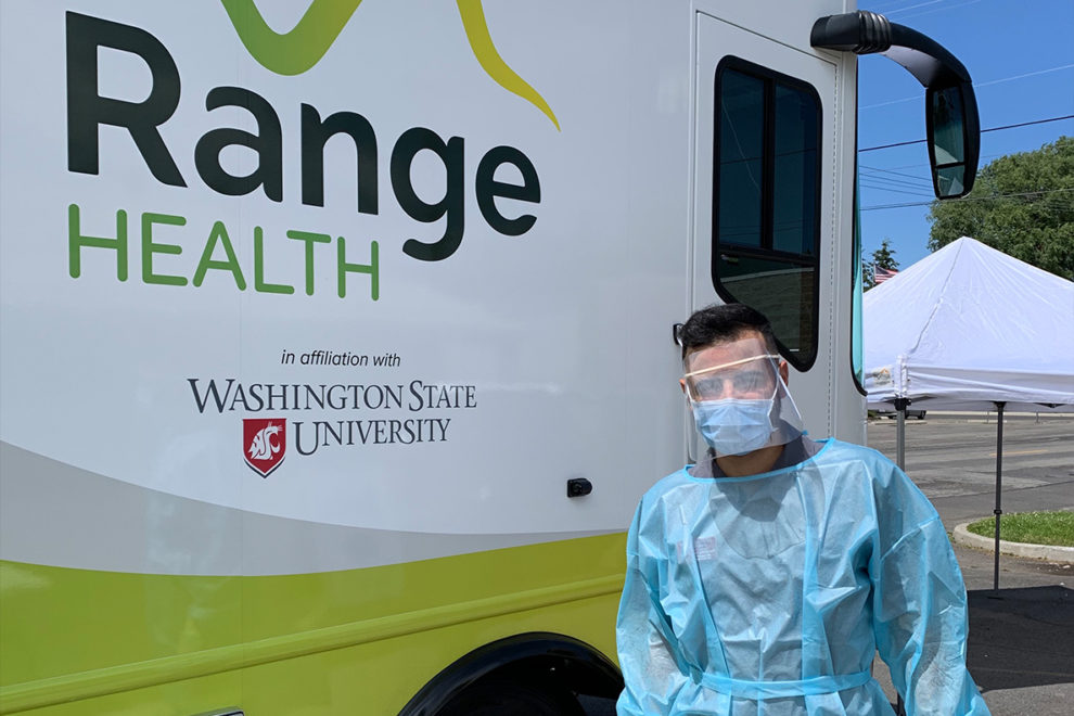 Sorosh Kherghehpoush standing next to the WSU mobile health care unit.