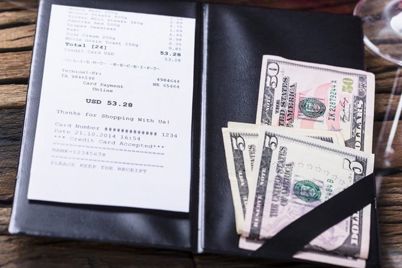 Cash and receipt on a restaurant table.