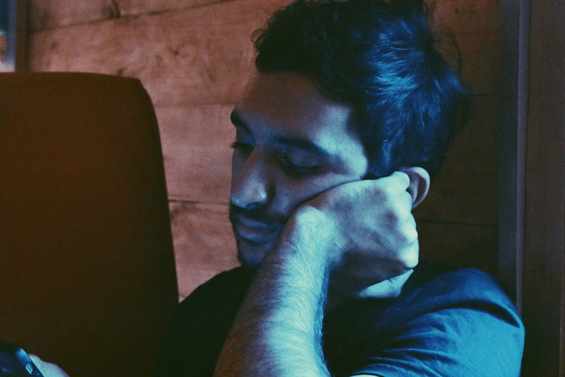 Depressed man looking at his smartphone.