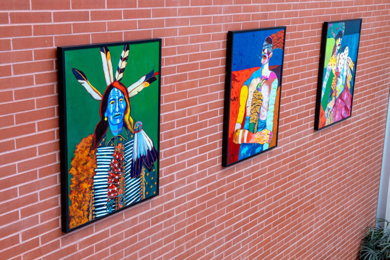 Three paintings hang on a wall.
