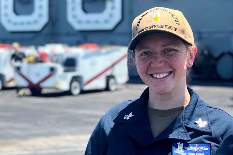 Closeup of Jenn Lewis on an aircraft carrier flight deck.