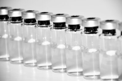 A line of clear vaccine vials.