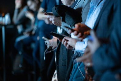 Closeup of a line of people holding their cell phones.