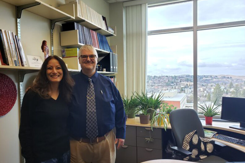 Paul Bolls and Porismita Borah pose for a picture in an office.