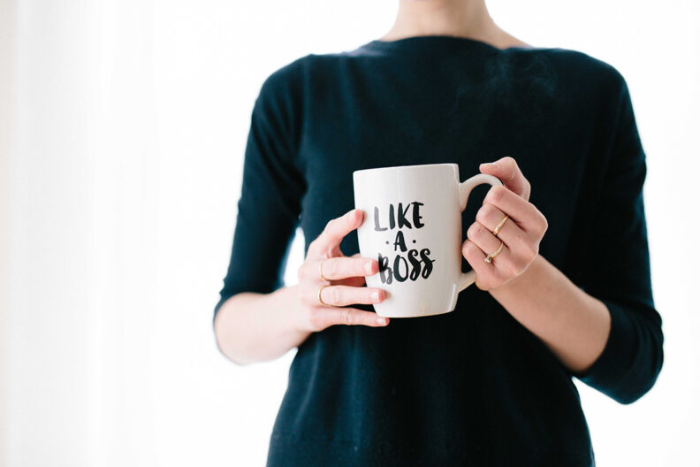 Woman holding a white mug that says "Like a Boss"