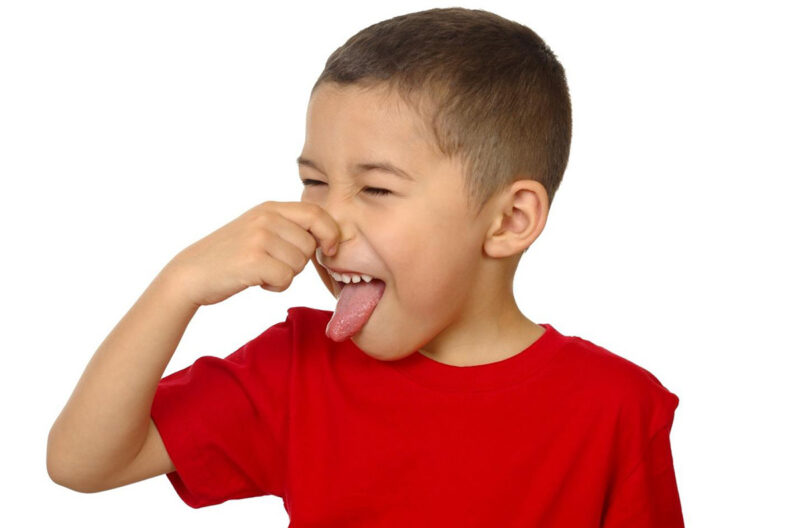 Child holding his nose and sticking out his tongue.