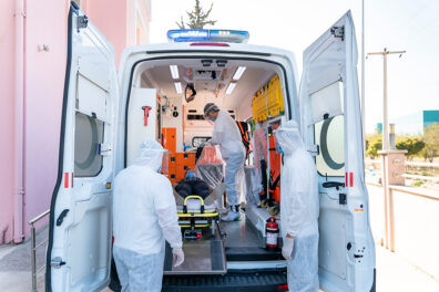 Health care workers moving a patient out of an ambulance
