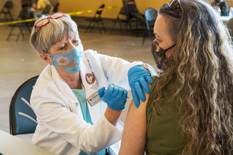 Jo Ann Dotson administers a COVID vaccine.