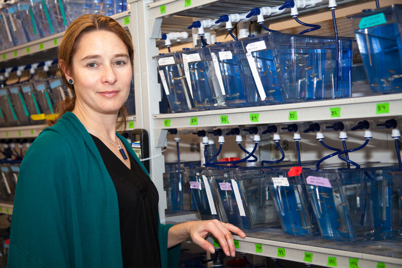 Allison Coffin stands in front of shelves filled with containers