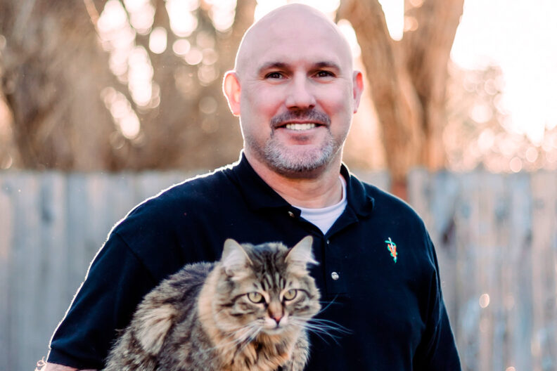 Closeup of Ryan Baumwart holding a cat.