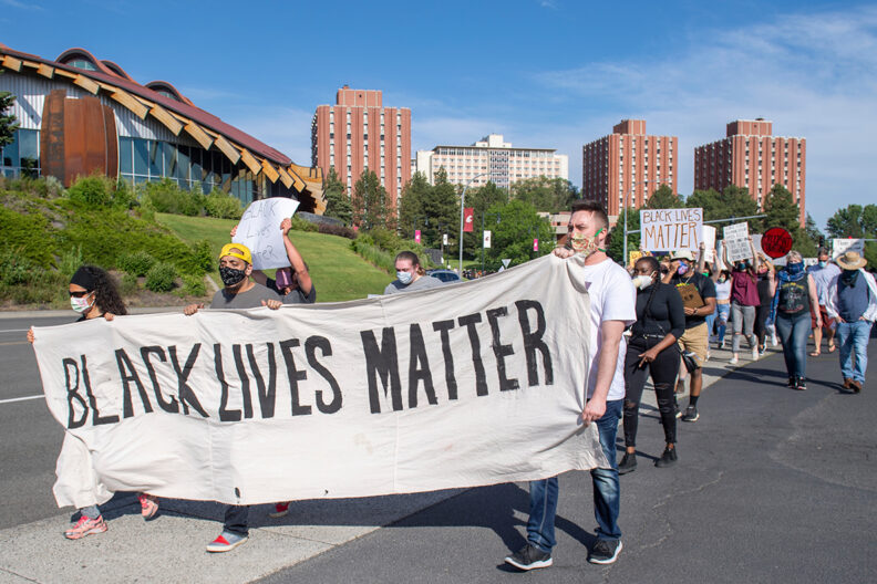 Black Lives Matter supporters march near the WSU Pullman campus with signs and banners.