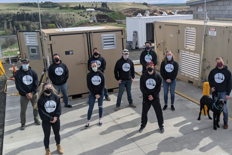 Student researchers pose for a picture on the roof of a building.