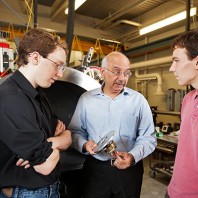 A photo of Yogendra Gupta talking to students in a lab