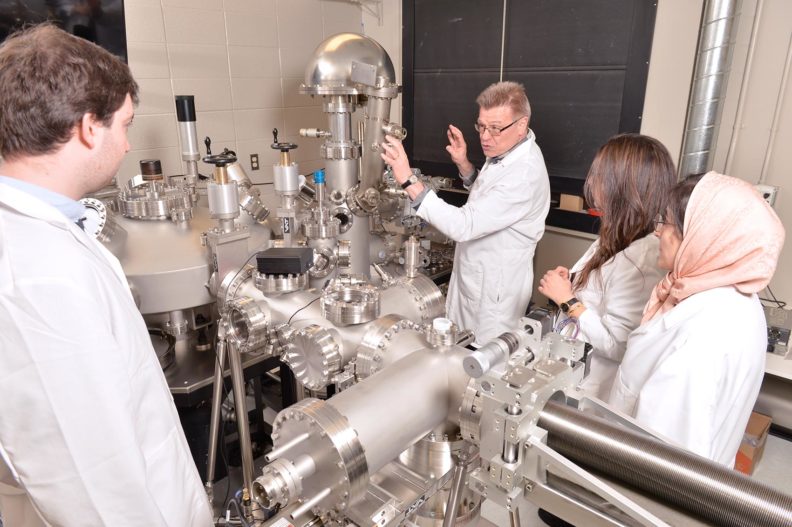 Norbert Kruse working with his students in the lab