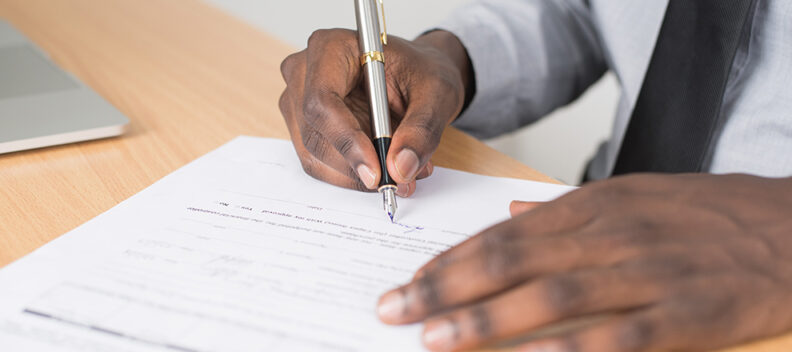 Hands with pen filling out form