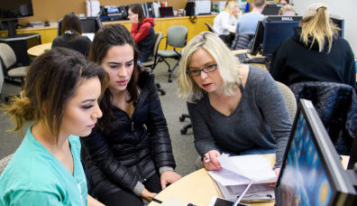 Students and instructor at computer in classroom