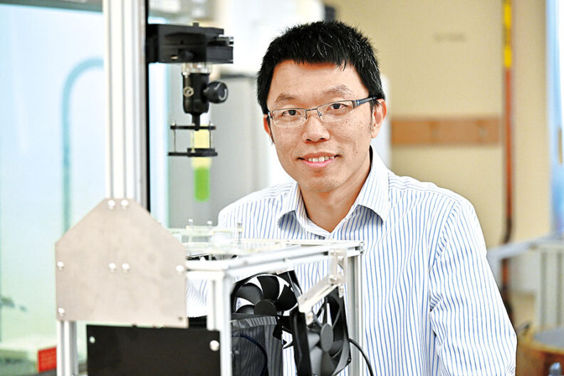 WSU engineer Roland Chen in his lab next to a customize 3D printer